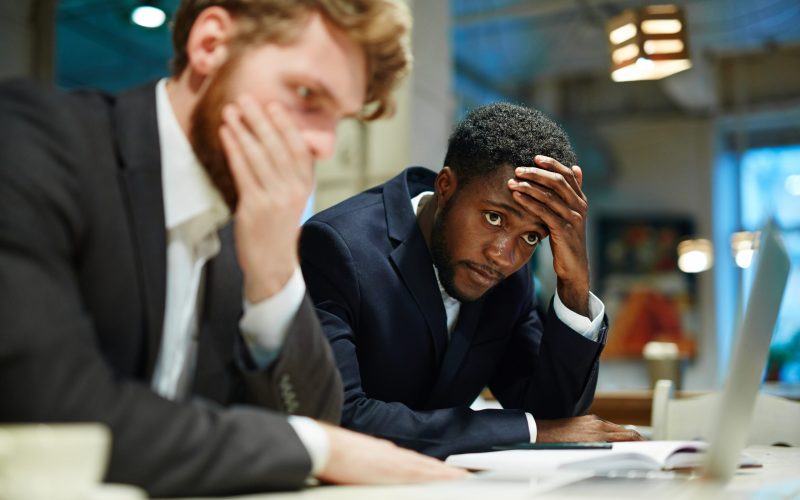 Stressed businessmen looking at laptop display