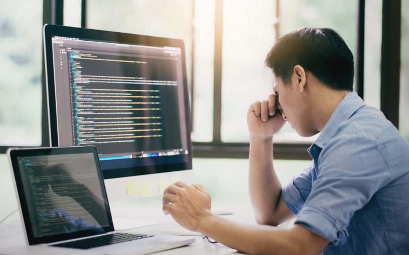 Stressed young programmer or software developer  having the problems with code bug and some error programming.
